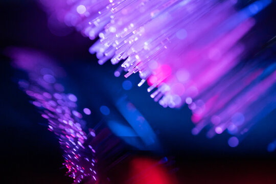 Fiber optic technology background with neon purple light