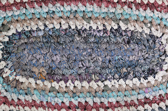 Old handmade rag rug, traditional rustic woven textile texture.