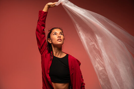 Latin woman dancer with flowing fabric in red light
