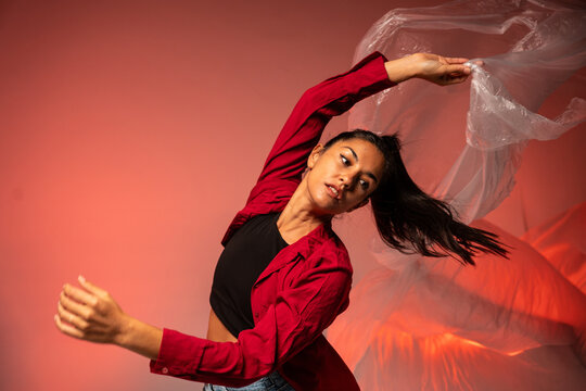 Latin woman dancer performing with flowing sheer fabric