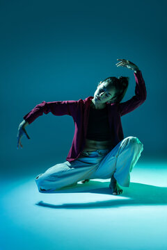 Latin woman dancer in expressive crouching pose