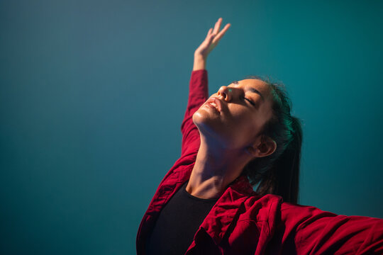 Latin woman dancer with closed eyes in red jacket