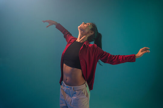 Latin woman dancer pose with outstretched arms in studio