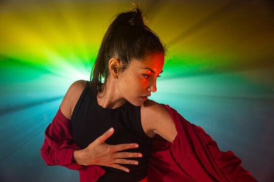 Latin woman dancer posing in colorful dramatic light