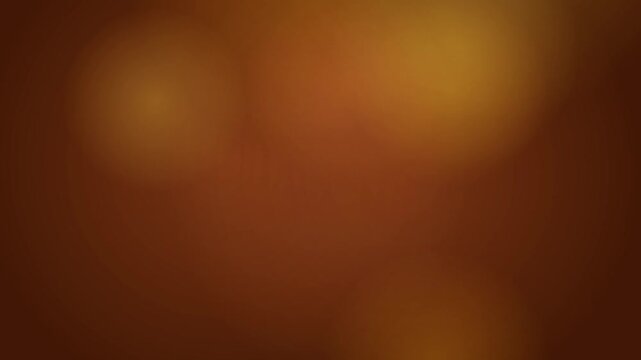 Abstract dark brown and copper out of focus light bokeh background. Soft blurry circular shapes and warm tones creating a cinematic and atmospheric texture for overlays or video backdrops.