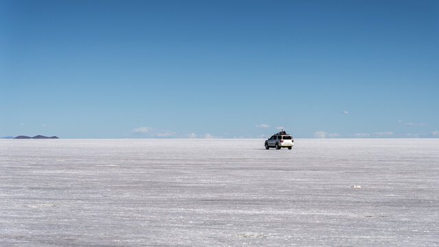 Off-road vehicle crossing Salar de Uyuni salt flat
