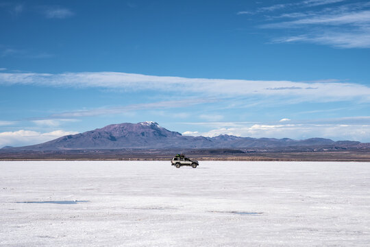 Off-road vehicle crossing Salar de Uyuni salt flat