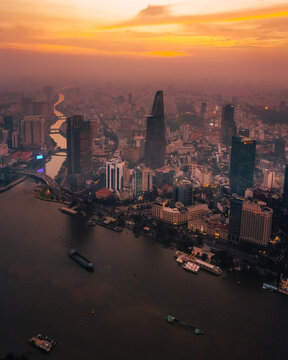 Aerial view of Saigon Skydeck and the surrounding urban skyline along the river during a golden sunset in Ho Chi Minh City, Ho Chi Minh, Vietnam.