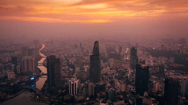 Aerial view of the Saigon Skydeck and Bitexco Financial Tower rising above the urban skyline at sunset, with the Saigon River, Ho Chi Minh City, Ho Chi Minh, Vietnam.