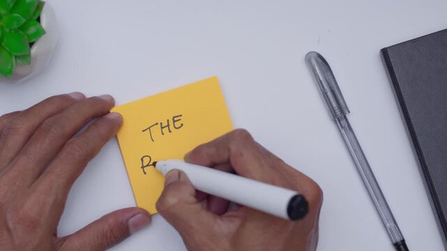 a man writing the results on orange sticky note