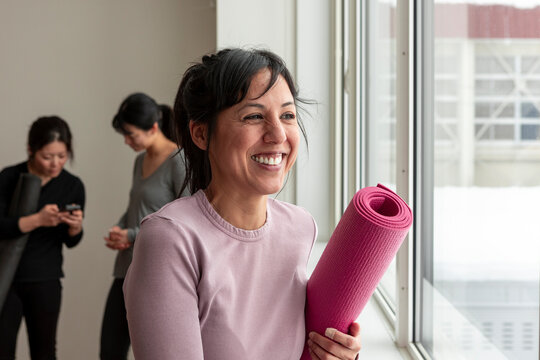 Japanese woman with yoga mat at wellness class