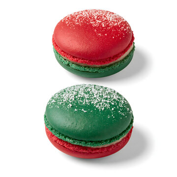 Colorful red and green macarons sprinkled with powdered sugar, perfect for festive occasions.