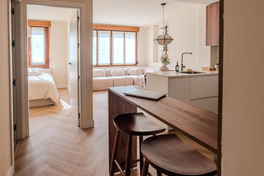 Modern apartment interior with kitchen island and bedroom