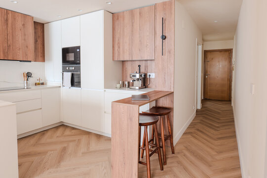 Modern apartment kitchen with wood cabinetry and breakfast bar