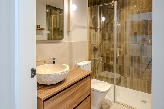 Modern apartment bathroom with shower and wood vanity