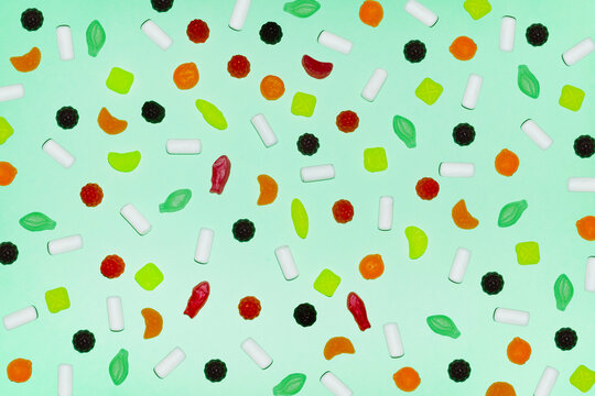 Colorful candy assortment on pastel green background