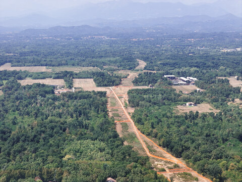 Aerial view of the construction of a new highway cutting through the Baraggia natural landscape with surrounding forests and fields in Gattinara, Piedmont, Italy.