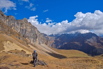Fototapeta premium Lone person observing the alpine mountains along Jomolhari trek in Bhutan