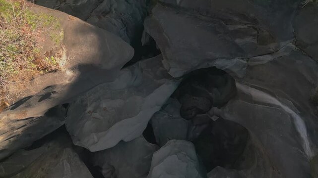 Giant quartzite potholes carved into the Sao Miguel River at Vale da Lua, Chapada dos Veadeiros National Park, Alto Paraiso de Goias, Brazil, top down drone forward flyover.