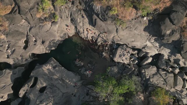 Quartzite plunge pool carved into the Sao Miguel River at Vale da Lua, Chapada dos Veadeiros National Park, Alto Paraiso de Goias, Goias, Brazil, top down drone slide.