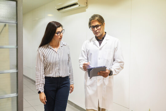 Doctor consults patient in modern medical clinic corridor