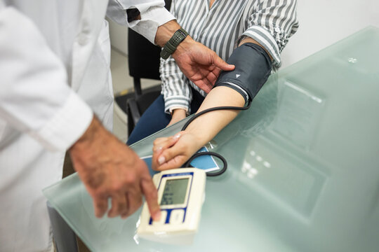 Doctor measuring patient blood pressure at medical clinic