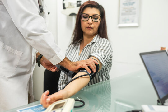 Doctor measuring patient blood pressure at medical clinic