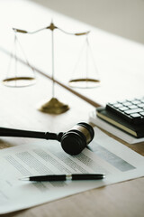 Obraz na płótnie Canvas Judge's gavel beside a contract document and scales of justice on a desk, symbolizing legal agreements, law, justice, courtroom decisions, and legal services.