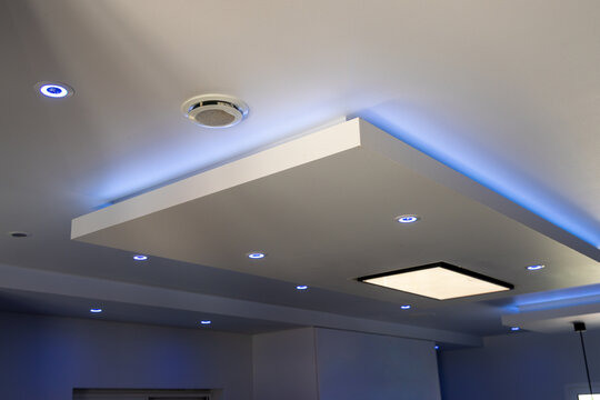 Modern recessed ceiling lights and ambient blue LED strip lighting create a sleek atmosphere