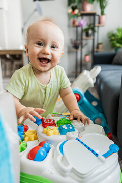 Smiling baby play with activity table at home