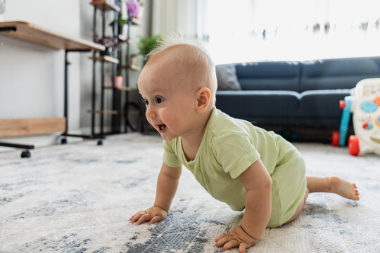 Baby crawl on carpet in bright family living room