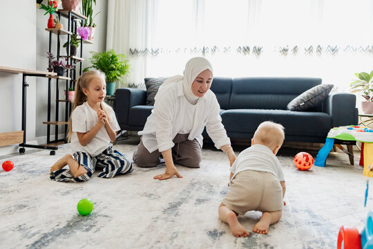 Mother play with children in bright family living room