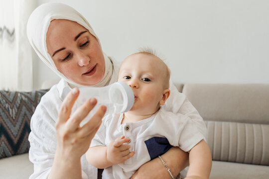 Mother feed baby with bottle at home