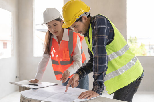 Concept Teamwork of building construction staff. Project engineer contractor reviewing plan of work with foreman and worker at construction site.