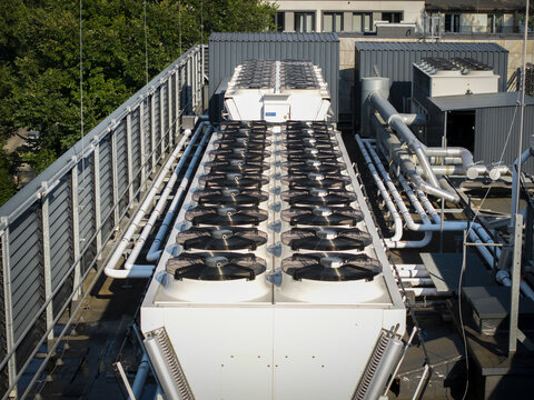 Aerial view of an AI data center cooling system with rows of industrial fans and metal piping installed on a rooftop in Krakow, Lesser Poland Voivode, Poland.