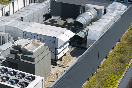 Aerial view of an AI data center cooling system featuring large industrial ventilation ducts, metal fans, and mechanical equipment on a rooftop in Krakow, Lesser Poland Voivode, Poland.
