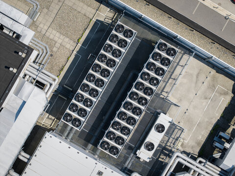 Aerial view of an AI data center cooling system with rows of industrial fans and ventilation pipes on a rooftop in Krakow, Lesser Poland Voivode, Poland.