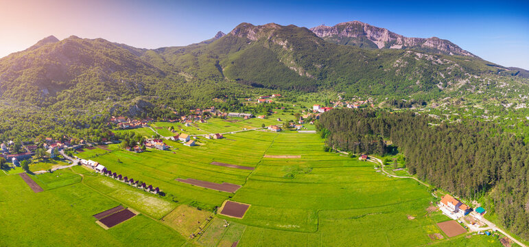 Njegusi village nestled in a mountain valley, showing traditional homes and green fields within Lovcen National Park, Montenegro