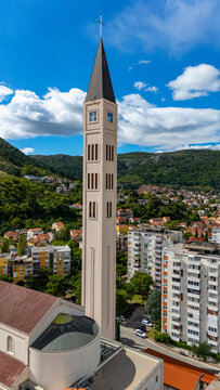 Aerial view of the Franciscan Church bell tower rising above the urban landscape of Mostar, Federation of Bosnia, Bosnia and Herzegovina.