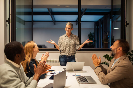 Diverse team applauding leader in office meeting