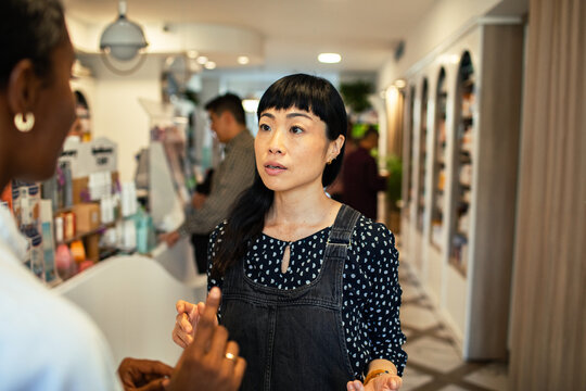 Woman consulting with shop assistant in beauty store