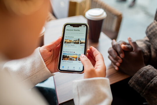 Travelers using smartphone city guide app at coffee shop