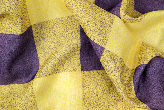 plaid fabric in purple and yellow large check pattern with a fold