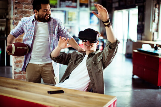 Two friends using virtual reality headset in creative office