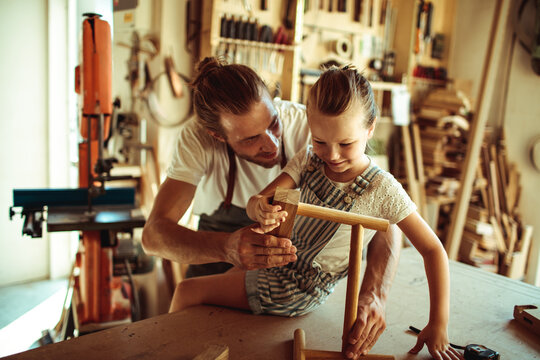 Father teaching daughter woodworking in woodshop