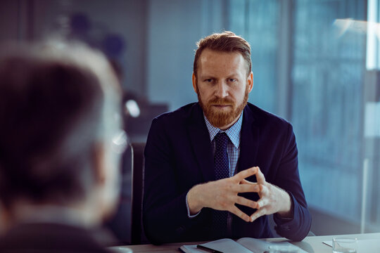 Confident manager interviewing candidate in modern office