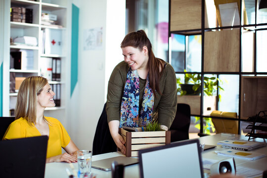 Smiling coworkers welcoming new colleague in modern office