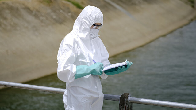 Environmental Inspector Completing Water Quality Inspection Report Beside Canal
