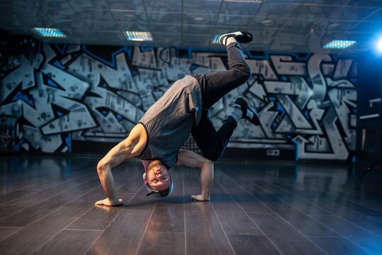 Breakdancer boy executing dynamic headstand balance with bent knees