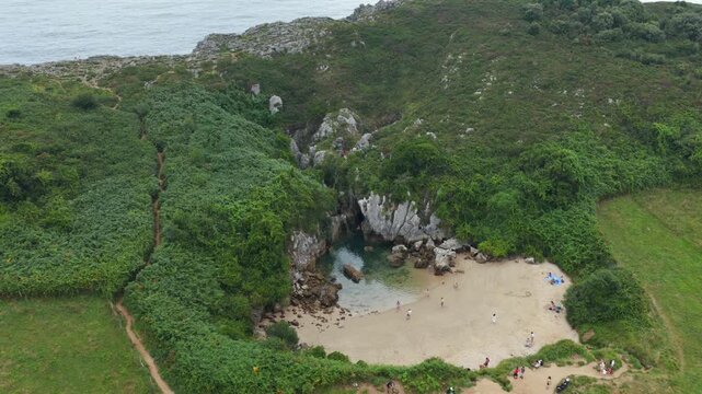 Aerial View of the Unique Inland Tidal Beach of Playa de Gulpiyuri Surrounded by Green Cliffs and Meadows in Asturias, Northern Spain